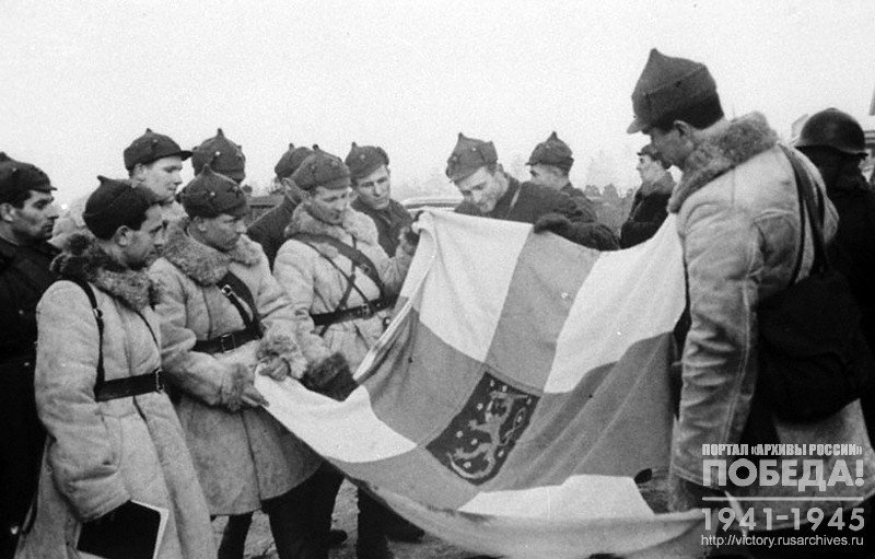 Группа советских командиров и бойцов осматривает отбитое у финнов знамя Шюцкора