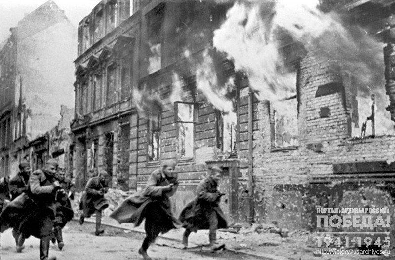 Soviet soldiers running down the burning Berlin’s street