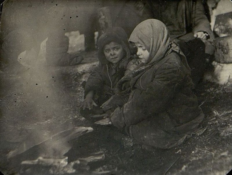 Image: Lyova, 3 years old, Zina, 6 years old, warming up by the fire