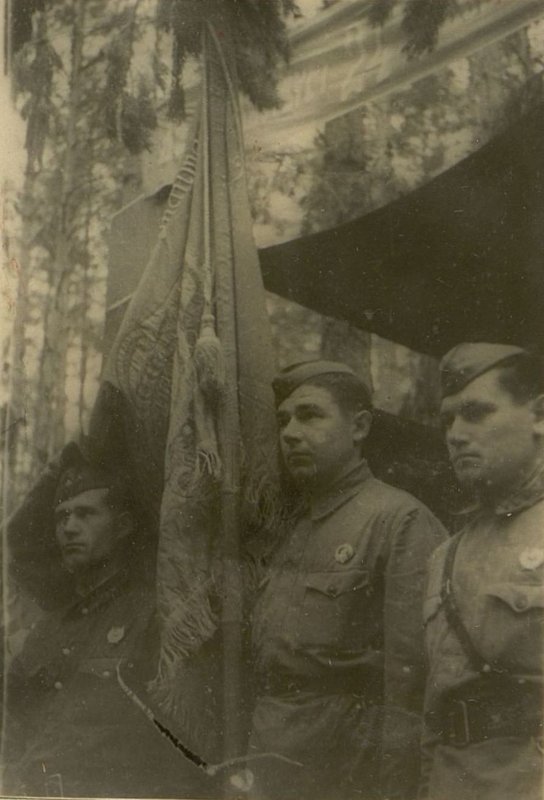 Фотография: Слева направо: капитан Павличенко, Старший Сержант  Поставнев и старший лейтенант Пипченко принимают переходящее Красное Знамя от представителей Бурят-Монгольской АССР