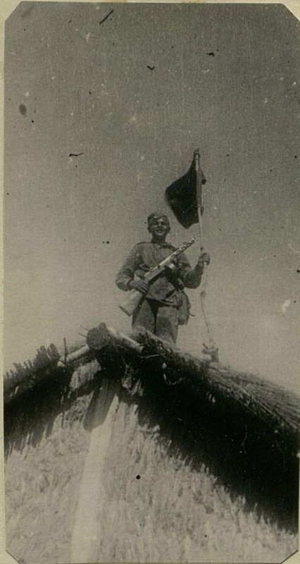 Фотография: Поселок Тачо взят. Ефрейтор Шувало устанавливает флаг на одном из домов