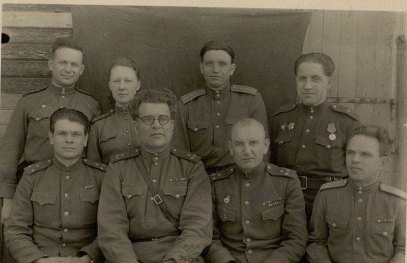 Image: Sitting (from left to right): Head of the Political Department of the special units of the front, Colonel Comrade Kondakov, regiment commander Colonel Comrade Peslyak, Assistant Chief of Staff of the Front Guard Colonel Comrade Sychev, Deputy Regiment Commander for political affairs, Lieutenant Colonel Comrade Ilyukhin; standing - Political Department agitator Major Comrade Dyachenko, instructor of the Political Department, Captain comrade Gagarinskaya, party organizer of the regiment, Major Kravtsov, Executive Secretary of the Party Commission, Major Comrade Klykov.