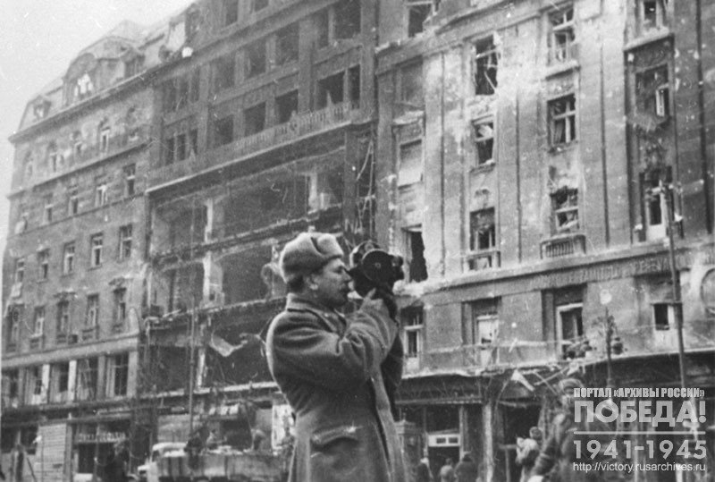 Фронтовой кинооператор А.И. Фролов во время проведения киносъемки на одной из улиц г. Будапешта