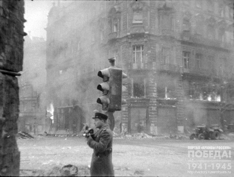 Фронтовой кинооператор Ю.М. Кун во время проведения киносъемки на одной из улиц г. Будапешта