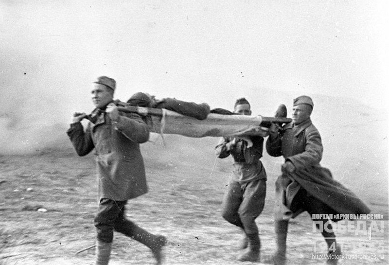 Combat medics carrying the wounded off the battlefield in stretchers