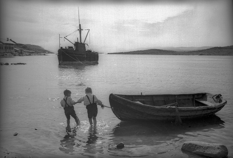 Young boys pulling a boat