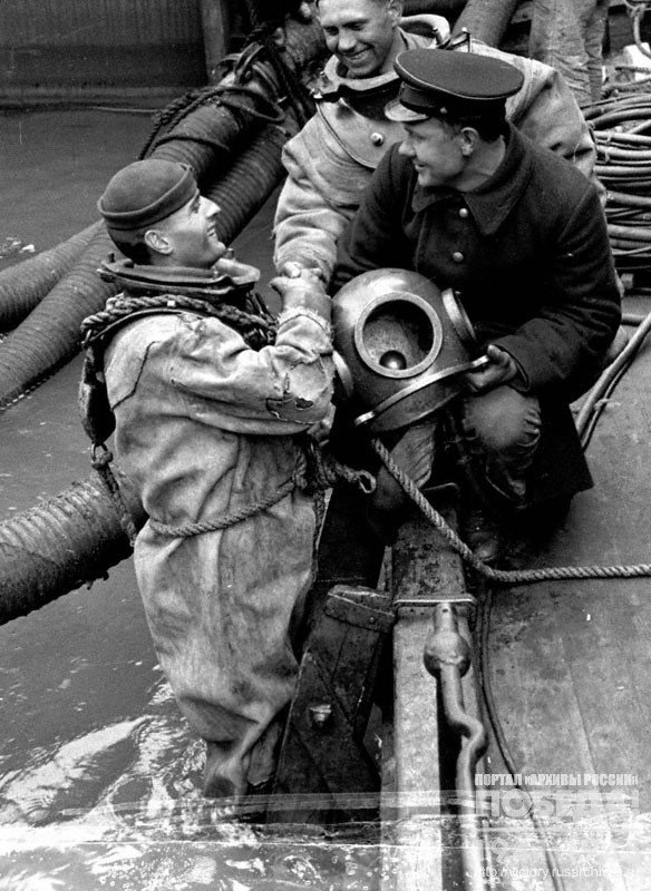 Red Navy men of the guards cruiser "Red Caucasus" ("Krasny Kavkaz") congratulate a Komsomol member, a diver I. A. Nevtrulov with the award of the Order of the Red Star