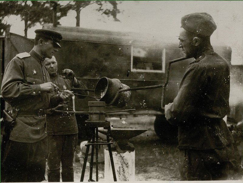 Фотография: Капитан Пошелюжный, Красноармеец Леви и Красноармеец Левченко на армейской выставке отливают поршиня отечественных