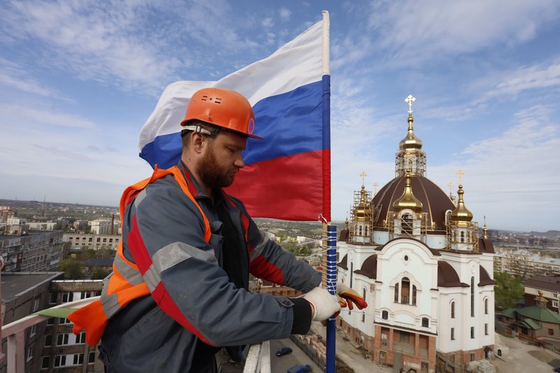 Флаг Российской Федерации на отреставрированном здании водонапорной башни в историческом центре Мариуполя, ДНР