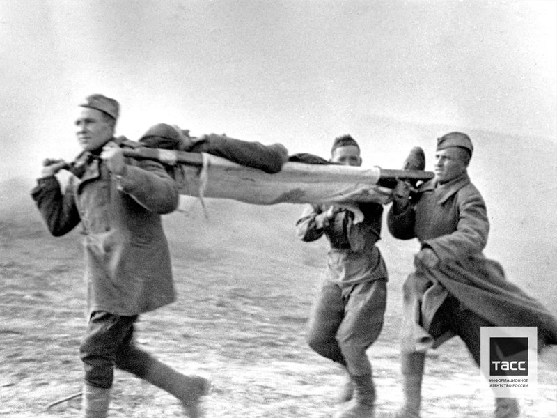 Солдаты выносят раненого с поля боя во время Витебской наступательной операции