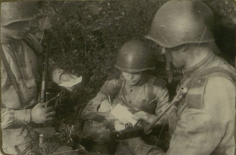 Фотография: Перед атакой парторг роты товарищ Климанов пишет листок-молнию, в котором призывает бойцов отомстить врагу за гибель сержанта Калинина, зверски замученного японцами