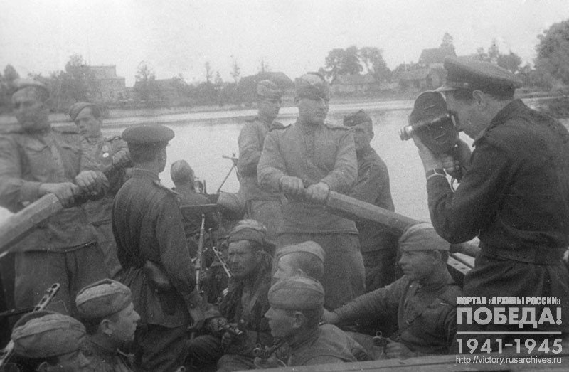 Кинооператор Союзкинохроники С.С. Школьников во время проведения киносъемки форсирования р. Лиелупе советскими частями