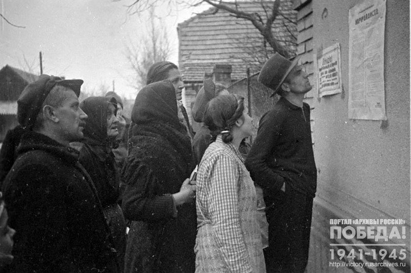 Жители освобожденного от гитлеровцев Будапешта читают приказ, вывешенный на стене одного из домов