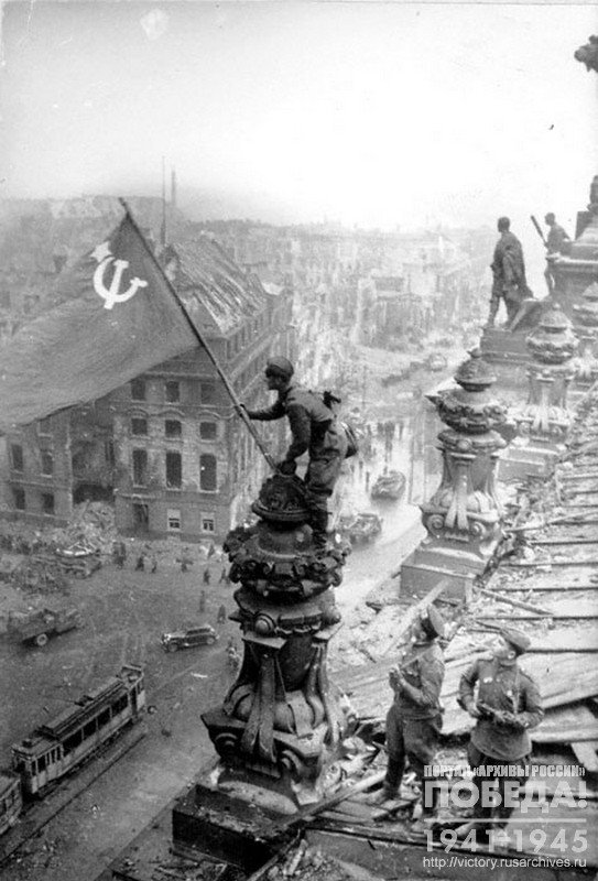Soviet soldier flying  the Victory  flag  over the Reichstag, Berlin, Germany, May 2nd 1945