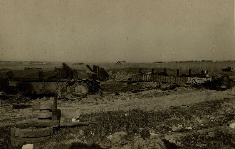 Фотография: Танк на обочине шоссе в районе 3 км. зап. Могилев, разбитый прямым попаданием ФАБ-100. Отдельные части танка (гусеница, башня) разбросанные от него в радиусе до 30 метр