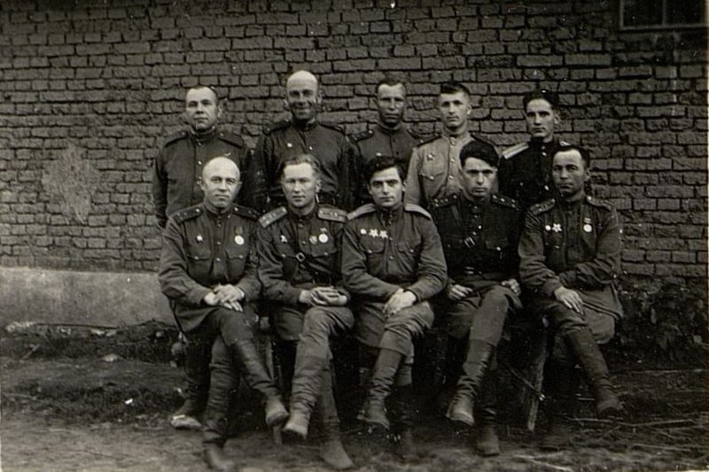 Фотография: Сидят слева направо: завдел старший лейтенант Плащевский, Помощник Начальника Штаба-1 (ПНШ-1) майор Конощенков, Начальник штаба майор Гацуленко, Помощник Начальника Штаба-4 (ПНШ-4) капитан Кравцов, Нач. связи капитан Штыликов; Стоят: завдел офицерского состава старшина Шведчиков, Помощник Начальника Штаба (ПНШ) по тылу старший лейтенант Курило, нач. хим. службы капитан Макурин, Помощник Начальника Штаба-6 (ПНШ-6) Лейтенант Гаврилов, Помощник Начальника Штаба-2 (ПНШ-2) Лейтенант Титов