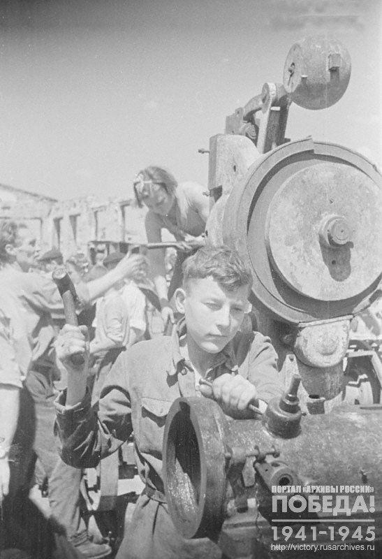 Exemplary student of the 17th school of FWT (Factory and Works Training) of Stalingrad S.B.Balashov repairing a turning machine