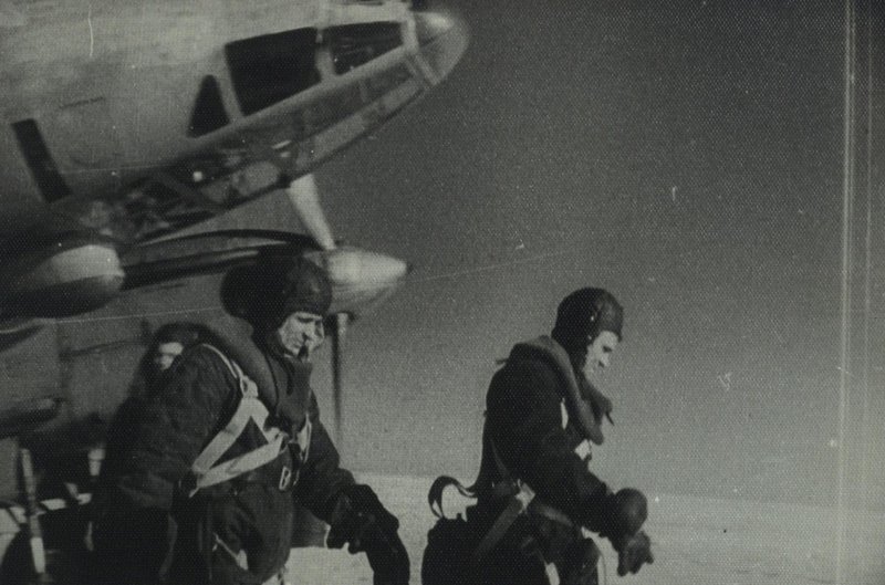 Members of PE-2 aircraft crew are walking from the aircraft alongside an air-field after completing combat mission
