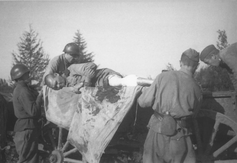 Soviet orderlies placing a wounded soldier on a horse-drawn cart. Sakhalin