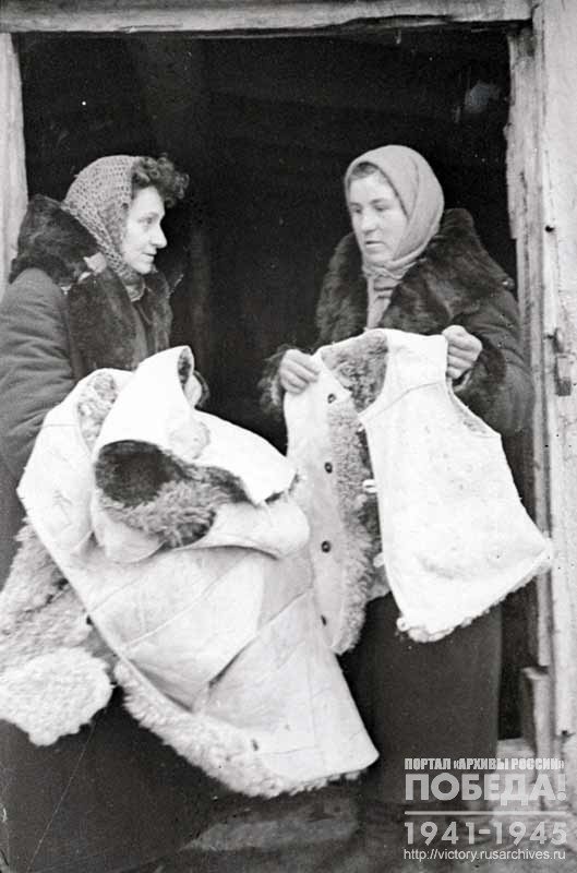 Members of the Chapaev collective farm M. Kazachinskaya and M. Shalaeva prepare warm clothes for Soviet soldiers to be sent to the front