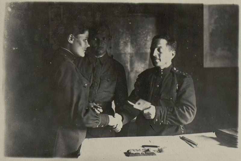 Image: Assistant to the Head of the Komsomol Political Department for the Captain Vinogradov presents Komsomol tickets