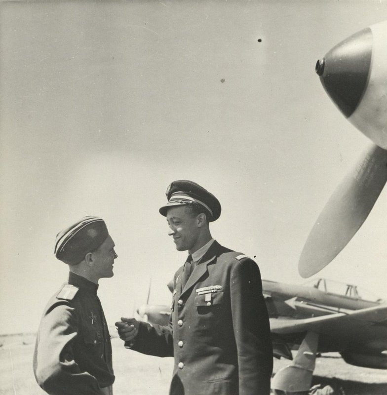 Soviet mechanic Yuri Filippovich Fedorin and French pilot Roger Sauvage are talking near the plane.  