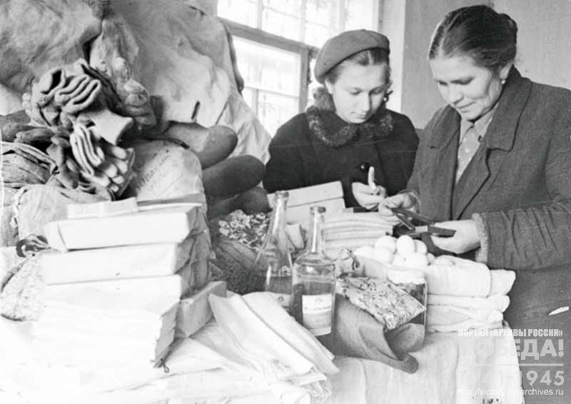 The wife of the supervisor of the railway station "Klin" A. Vasilieva and a member of the Commission for collecting gifts for front line soldiers A. Kozlova pack parcels with gifts for Soviet fighters