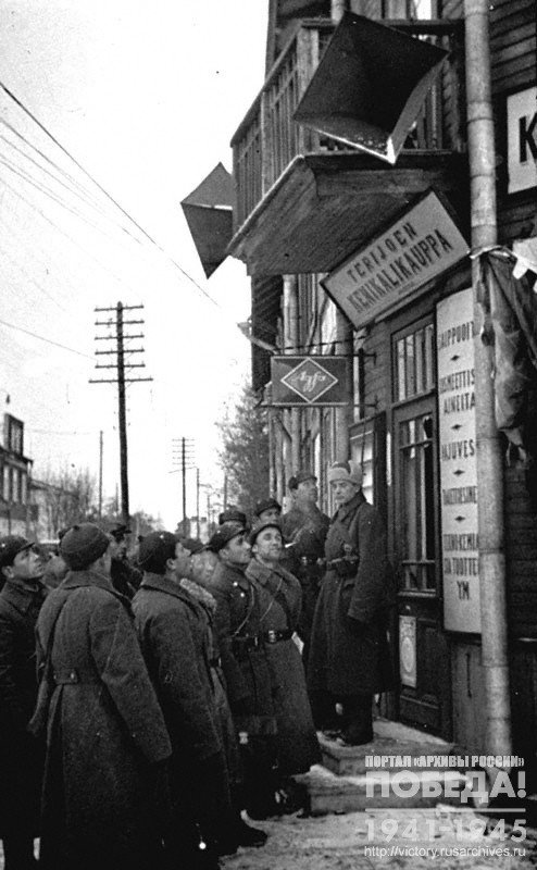 Red Army soldiers group and commanders standing on some of the streets under a radio and listening to the radio broadcast