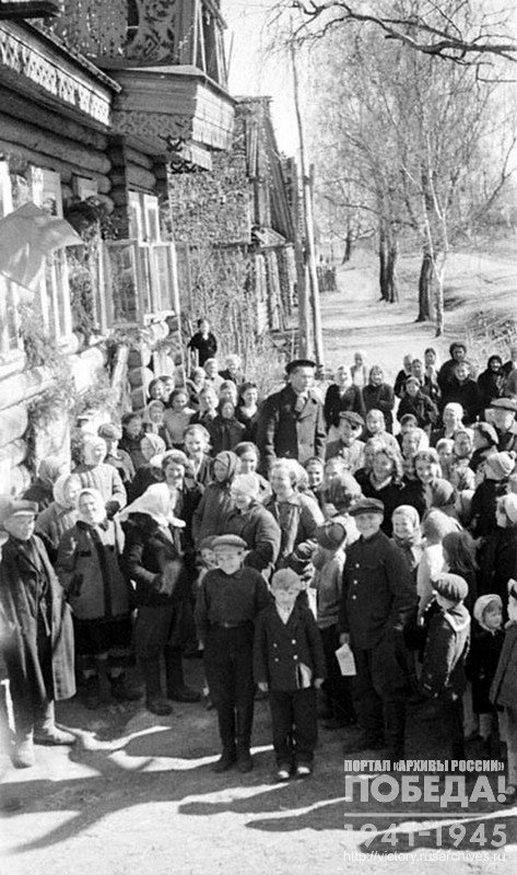 Triumphant inhabitants on the street of "Novy Put" collective farm, located in Luzhskiy region