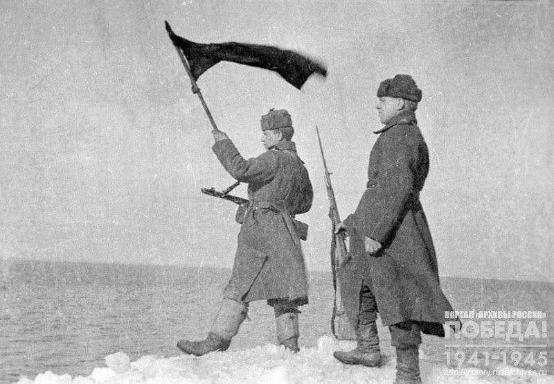 Soviet soldiers with a Red Flag on the coast of the Baltic sea