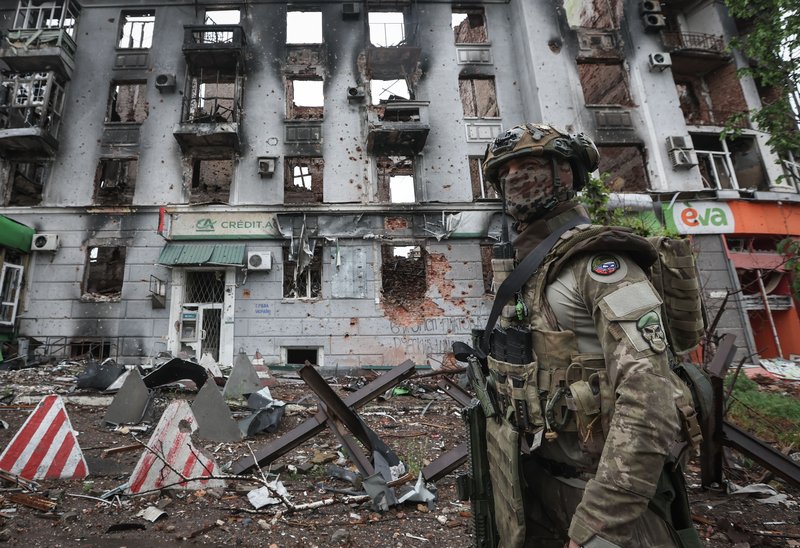 Ситуация в Артемовске. Россия. ДНР. Артемовск. Военнослужащий частной военной компании (ЧВК) "Вагнер" у здания, разрушенного в результате обстрела