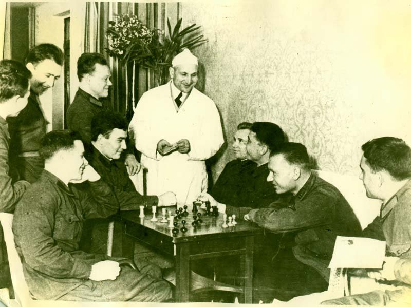 A group of recovering fighters during a game of chess. In the center - surgeon K.A. Gordon