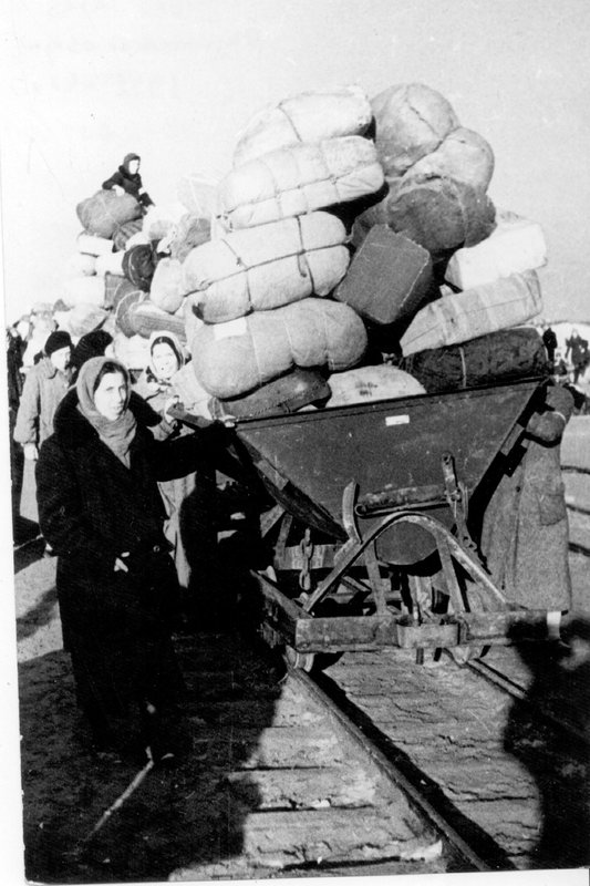 Эвакуированные везут вагонетки с вещами. 1942 г.