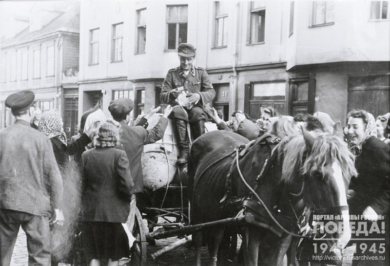 A volunteer of the Latvian SS Legion distributes tobacco to his countrymen