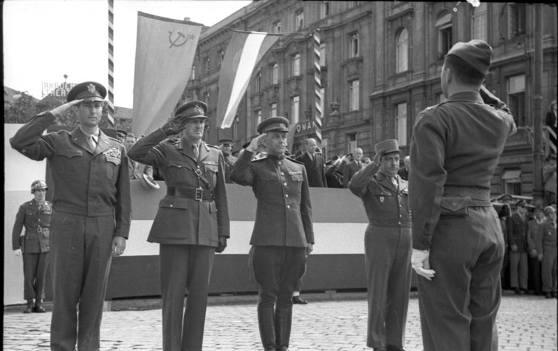 «Парад союзных войск в Вене, приуроченный к годовщине, победа над Германией. Принимающие парад представители союзного командования (генералы Кларк, Уинтертон, Курасов и Жоппе) принимают рапорт.»