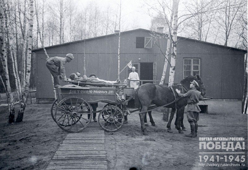 A wounded soldier being delivered to a medical post in a cart for heavily wounded