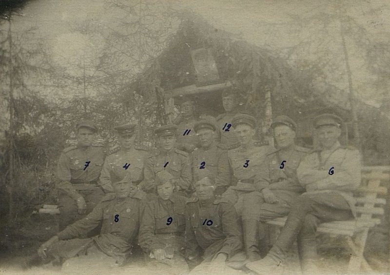 Фотография: фото на фоне квартиры командира батальона в д. Лейкино. 1 командир батальона гвардии майор Харламов. 2 зам. командира батальона гвардии майор Сукачев. 3 Начальник штаба батальона 4 Помощник командира  батальона по по материально-техническому обеспечению (МТО) - гвардии капитан Кремнев 5 командир 2-й инженерной роты гвардии капитан Сионский. 6 Начальник финдовольствия гвардии старший лейтенант интендантской службы л. Березняк. 7 Уполномоченный контрразведки "Смерш" гвардии старший лейтенант Маслов. 8 - командир отделения гвардии старший Сержант Михайленко. 9 - писарь старший Красноармеец Цветова. 10 парторг батальона гвардии ст. лейтенант Помачайбо 11 ординарец командира батальона гвардии ефрейтор Сурков. 12 - писарь 3й инженерной роты гварлии красноармеец Дятлов