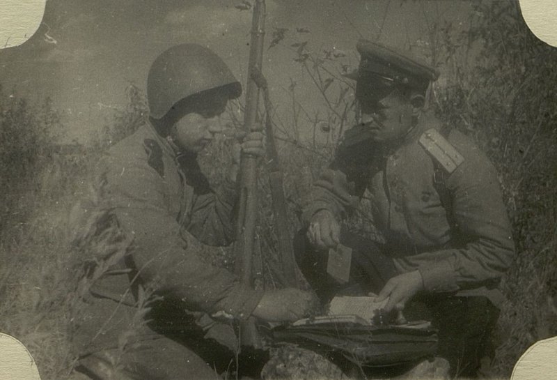 Фотография: Помощник Начальника  передового отряда (ПО) 8 Укрепительного Района старший лейтенант Бахтаев выдает Комсомольский билет красноармеецу Варламову