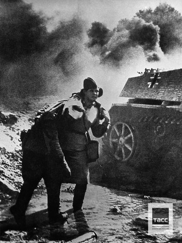 Санитарка выносит раненого с поля боя